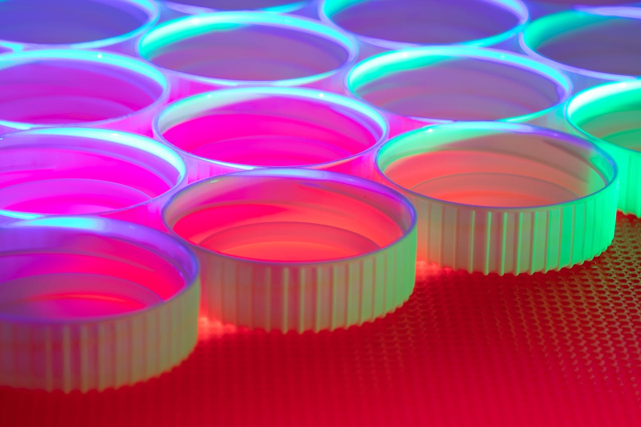 Vibrant plastic caps illuminated with colorful light, creating an abstract pattern.